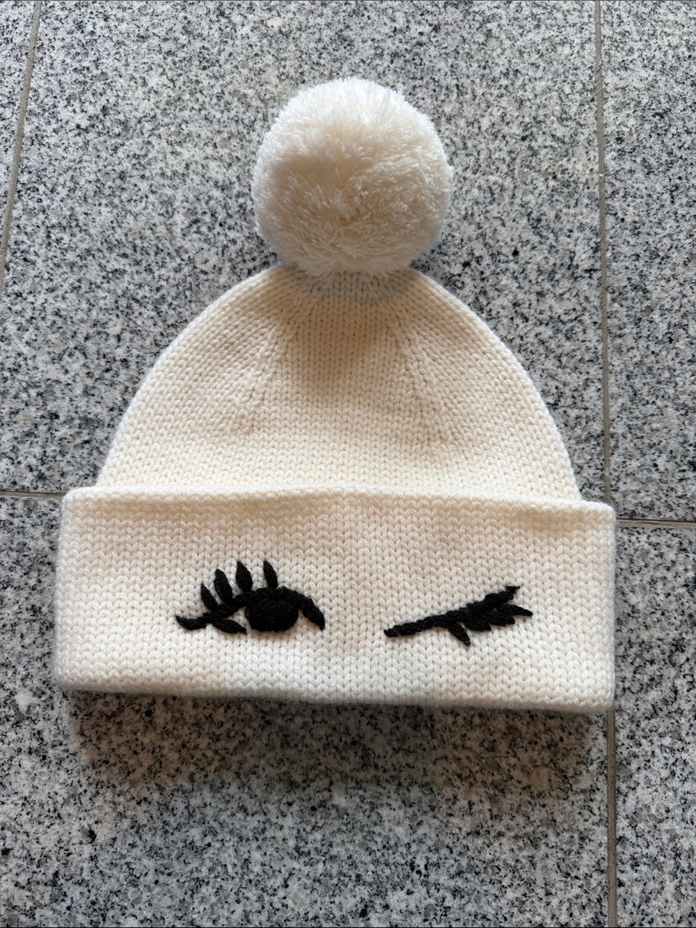 kate spade Cream Knit Pom Beanie with Black Eyelash Motif